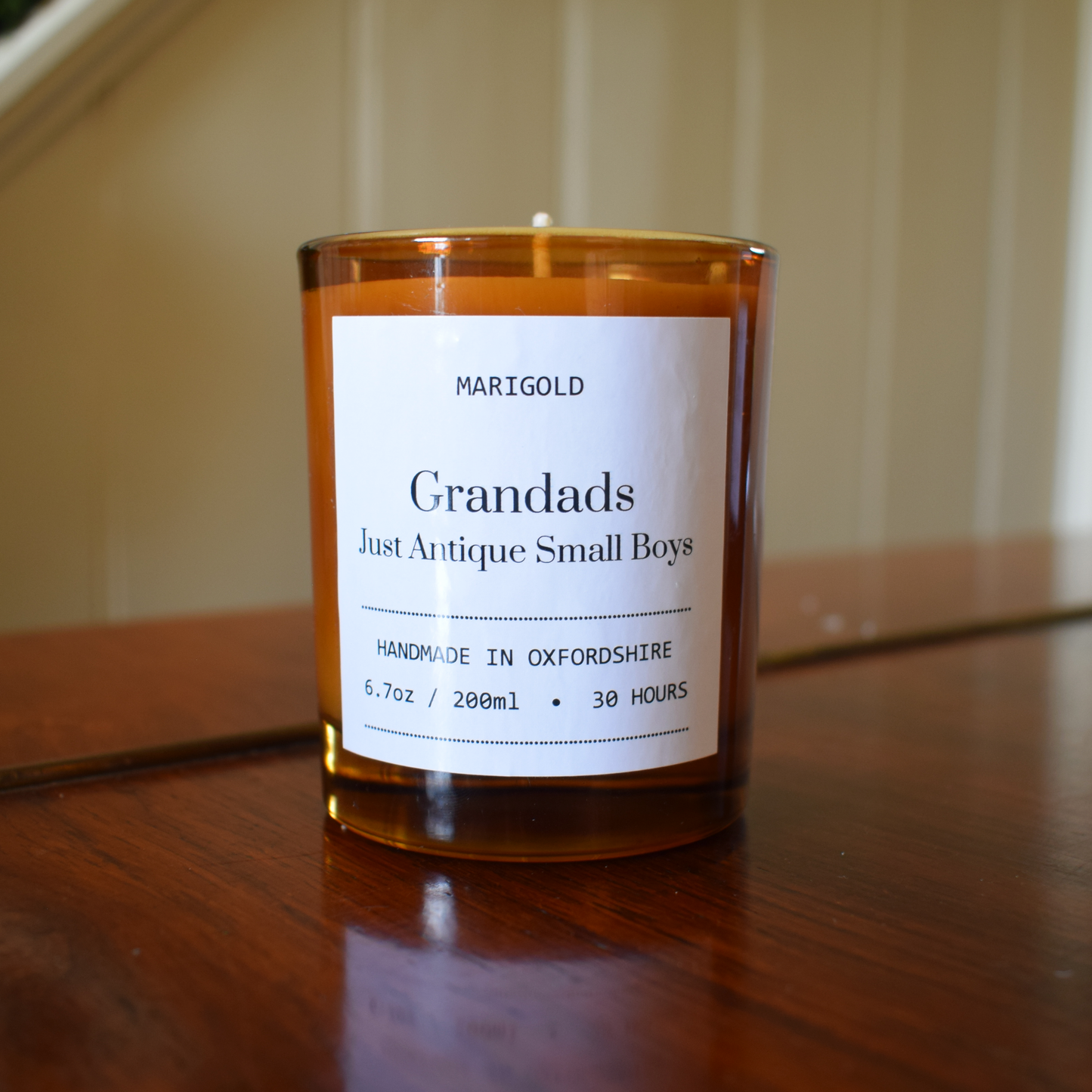 Candle with a label on a wooden surface