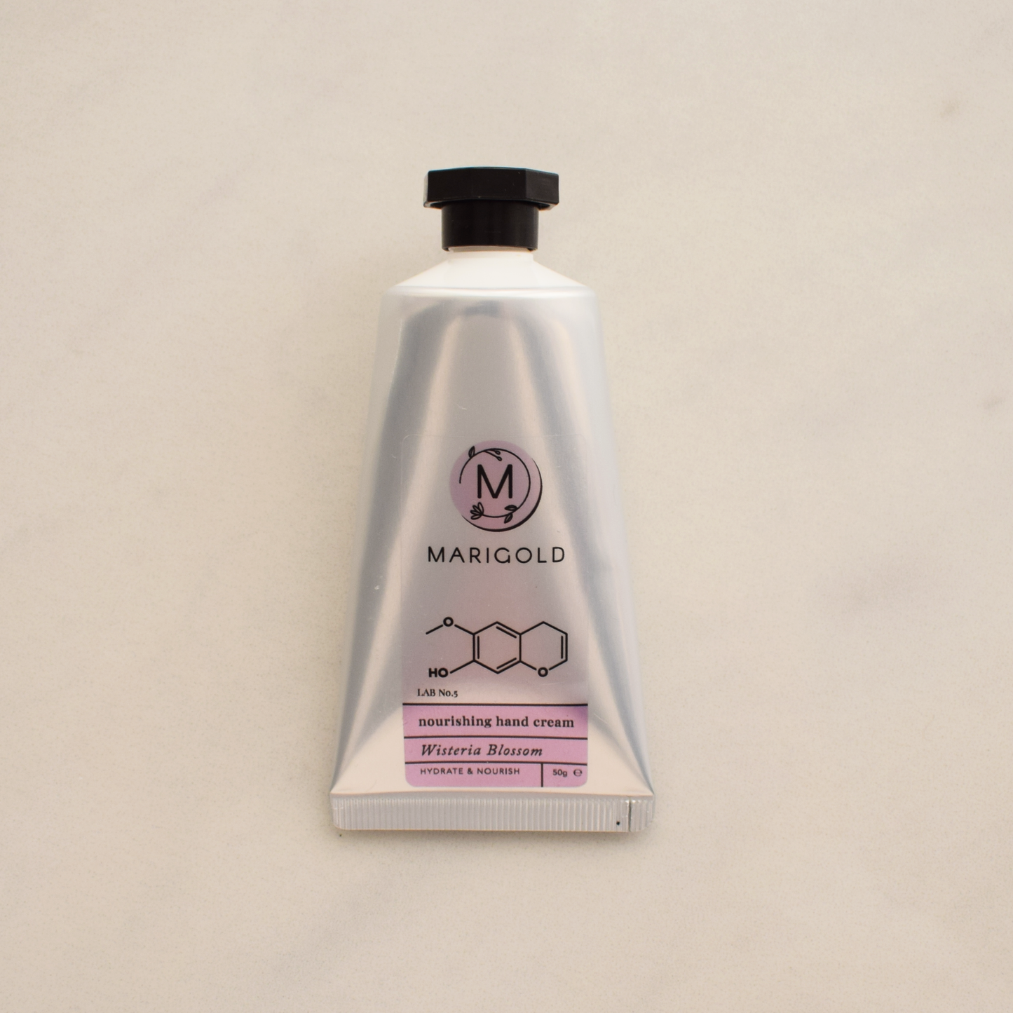 Wisteria Hand cream tube with Marigold branding on a beige background