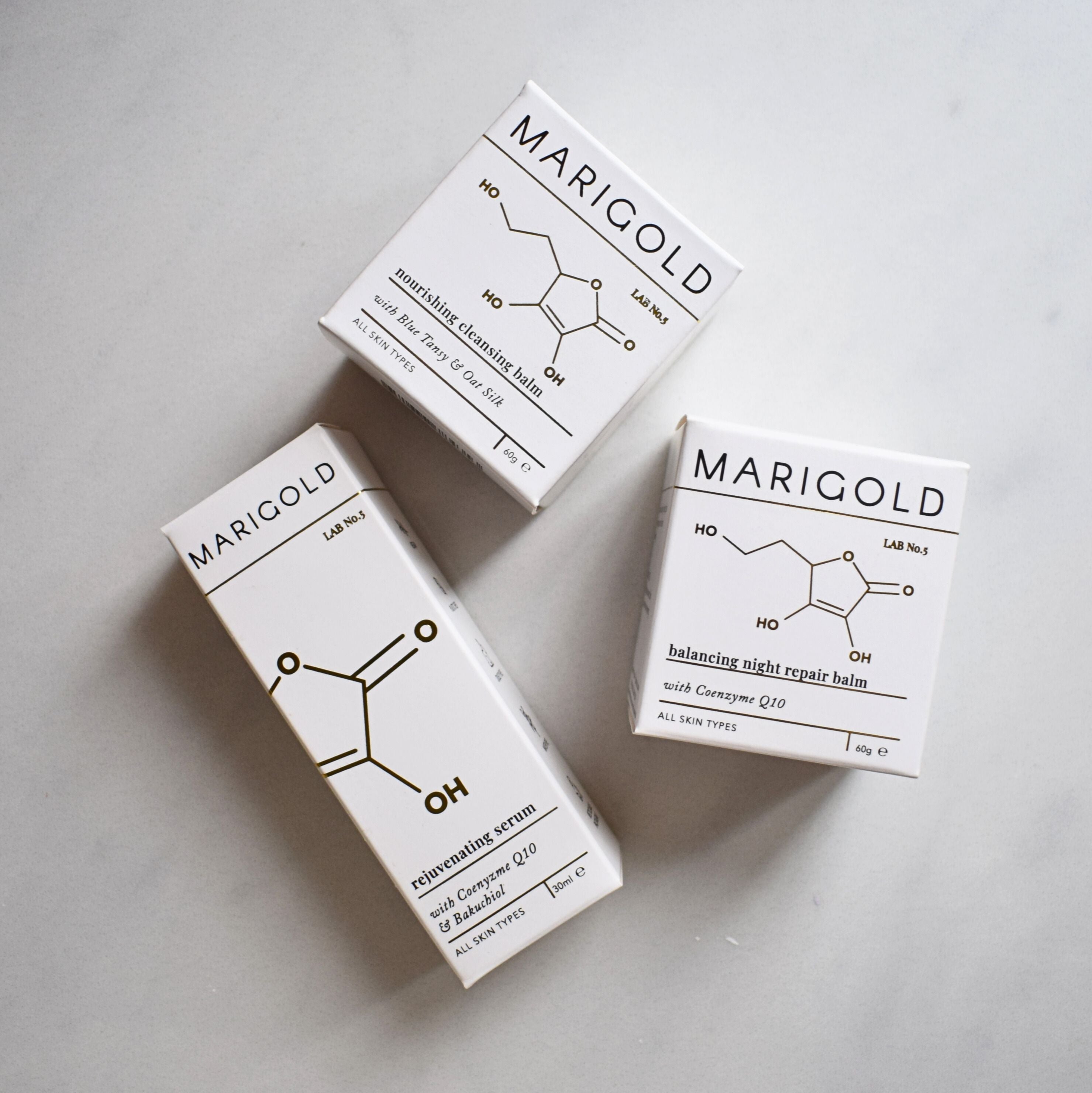 Three Marigold skincare product boxes on a light grey background